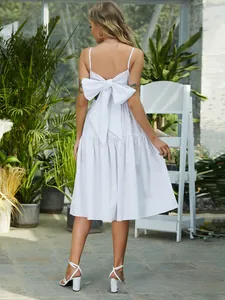 Detail of white bohemian maxi dress featuring a large bow on back with A-line skirt