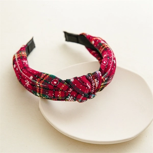 Detail of red and green plaid headband with white snowflake embroidery and twist knot