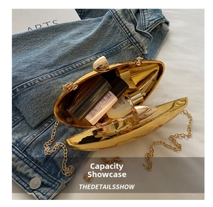 Golden mango shaped acrylic clutch bag showing interior capacity for cosmetics