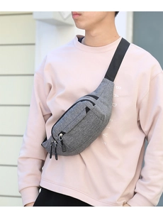 Detailed view of the grey fabric waist bag with multiple zipped pockets and adjustable strap