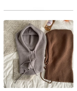 Close-up of gray and brown knitted balaclava hoods with drawstring details for winter