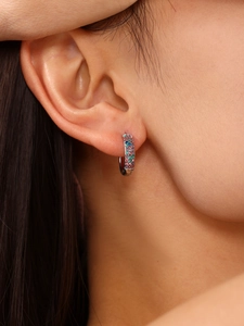 Close-up of multicolor zircon silver hoop earrings worn on ear showing craftsmanship