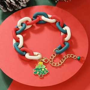 Detailed macro view of red and green Christmas chain bracelet with a green tree pendant