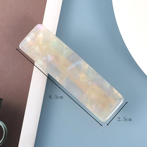 Detailed view of acetate hair clip with pearl texture and 8.5cm x 2.5cm dimensions