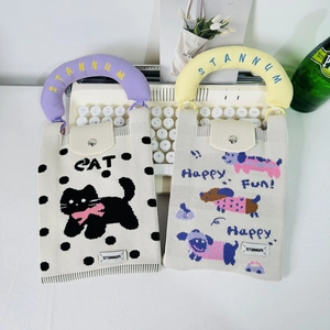 Detail of knitted mini bags featuring cartoon cat patterns and padded cotton handles