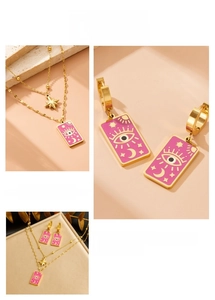 Macro detail of gold layered necklace and pink enamel boho astrology pendants