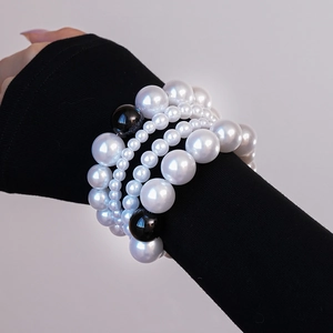 Détail du bracelet multi-rangs en perles avec perles noires sur le bras d'un mannequin
