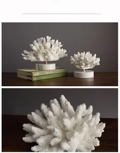 Detail of white resin coral decor on marble base with gold metal support rod