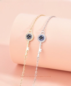 Detail of silver and gold evil eye key bracelets with sparkling colorful zircon stones