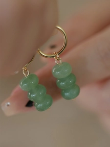 Detail of handmade gold hoop earrings with three natural green aventurine beads