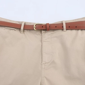 Close-up of khaki shorts waist with brown leather belt and golden metal buckle details