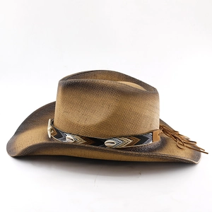 Detail of a woven straw cowboy hat featuring an ethnic band and seashell accents