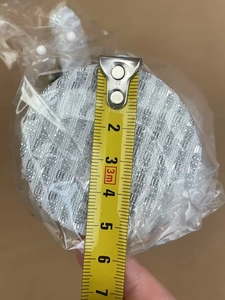 Top-down view measuring the 6.5cm diameter of the mini Christmas tree base with a tape measure