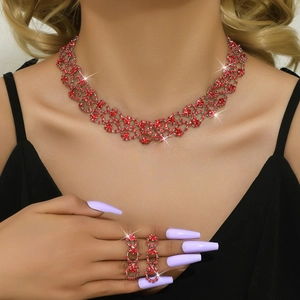 Close-up of elegant silver necklace and drop earrings set with sparkling red rhinestones
