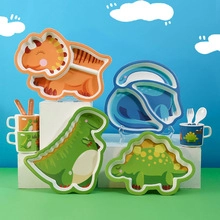 Detail of colorful dinosaur-shaped divided plates with matching cups and cutlery for kids
