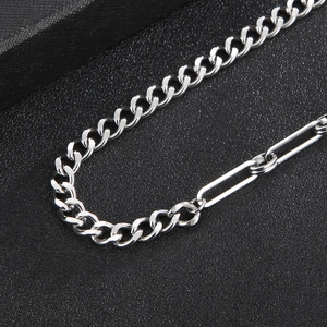 Macro detail of silver stainless steel cuban chain and paperclip link splice necklace