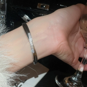 Detail of silver twisted open bangle with sparkling cubic zirconia on a wrist