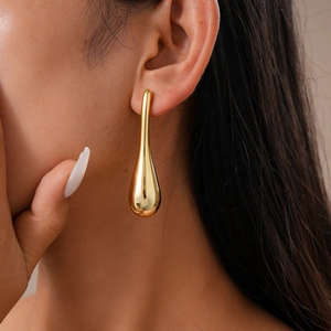 Detailansicht eines goldenen Tropfenohrrings mit glatter, polierter Metalloberfläche