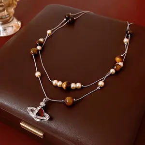 Vintage double-layer Saturn necklace featuring white pearls and tiger eye stone beads