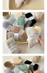 Detailed view of colorful ribbed wool socks in soft pastel shades with brand labels