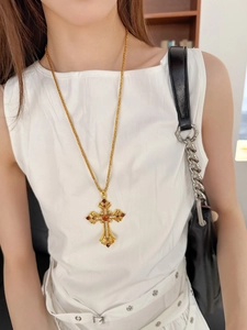 Collier croix dorée baroque avec pierres rouges et strass sur un mannequin femme