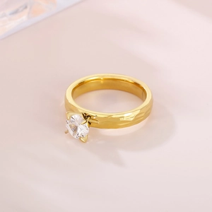 Detail of gold hammer-textured ring featuring a sparkling four-prong round zircon stone