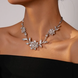 Detail of silver floral necklace with textured leaf design and sparkling diamond accents
