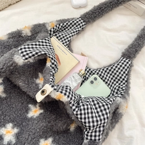 Detail view of large grey fuzzy tote bag with daisy patterns and checkered lining