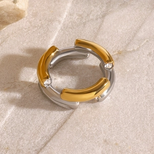 Two-tone stainless steel ring with cubic zirconia set on a textured stone background