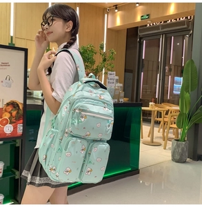 Detail view of a light green school backpack with cute bear prints and multiple pockets
