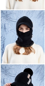 Detail of black winter knit hood with pom-poms and integrated neck gaiter for snow