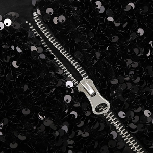 Détail de fermeture éclair en métal argenté et paillettes noires sur la robe
