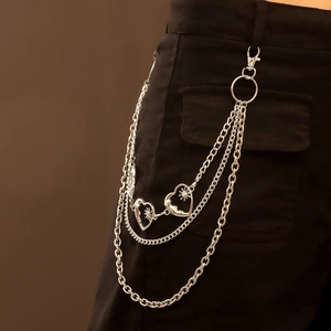 Macro view of multi-layer silver metal pants chain with hollow sunburst heart pendants