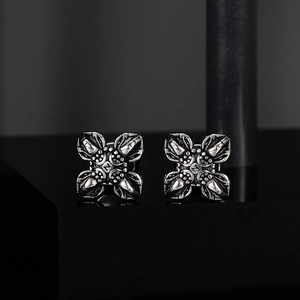 Macro detail of retro punk cross cufflinks with Z letter engraving and aged metal finish