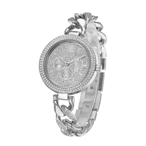 Macro shot of silver diamond-encrusted watch dial with Roman numerals and three sub-dials