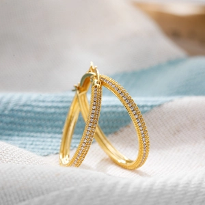 Macro shot of 18K gold hoop earrings featuring micro-pave cubic zirconia crystals