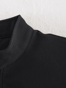 Detail of black sleeveless jacket showing twill fabric texture and collar stitching