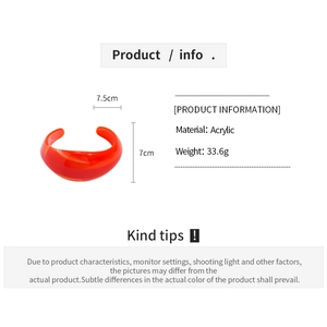 Detail view of orange acrylic open bangle showing dimensions 7.5cm width and 33.6g weight