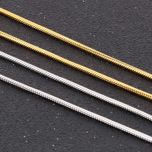 Macro shot of gold and silver stainless steel snake bone chains with scaled texture