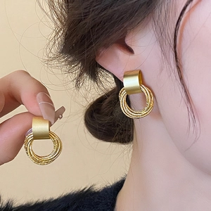 Detailed shot of vintage gold geometric hoop earrings with textured multi-layered texture