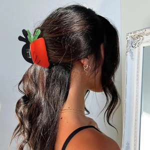 Close-up of a cute orange carrot hair claw clip securing a woman's half-up hairstyle