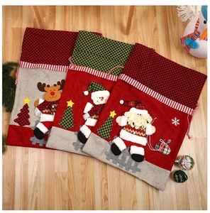 Close-up of three festive Christmas drawstring gift bags with 3D Santa and Reindeer designs