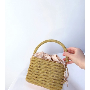 Detail of gold beaded bucket bag with champagne satin drawstring lining and metal handle