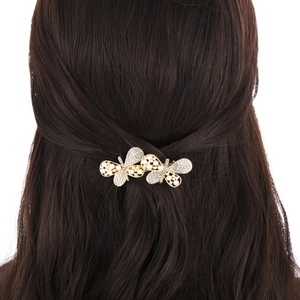 Elegant gold butterfly hair clip with pearls and rhinestones on dark brown hair