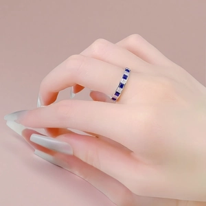Close-up of a silver titanium steel ring with square blue and white zircons on hand
