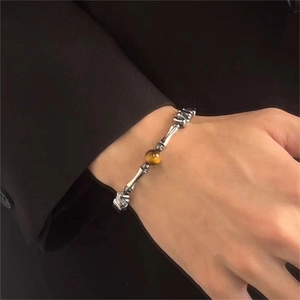 Dettaglio della perla occhio di tigre su un bracciale d'argento con design osseo vintage
