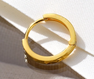 Macro close-up of S925 sterling silver gold earrings with diamond-cut geometric texture