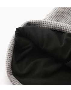 Detailed close-up of grey waffle knit exterior and soft black warm lining of the beanie