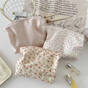 Detail of floral makeup bag with metal zipper showing soft cotton fabric and print
