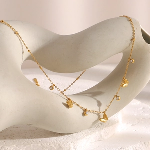 Detail of 18K gold-plated butterfly pendant with zircons on a beaded chain necklace